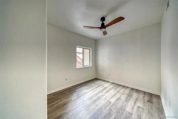 a view of empty room with wooden floor