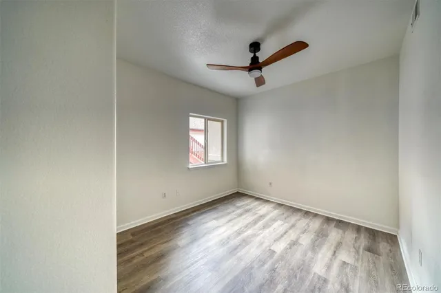 a view of empty room with wooden floor