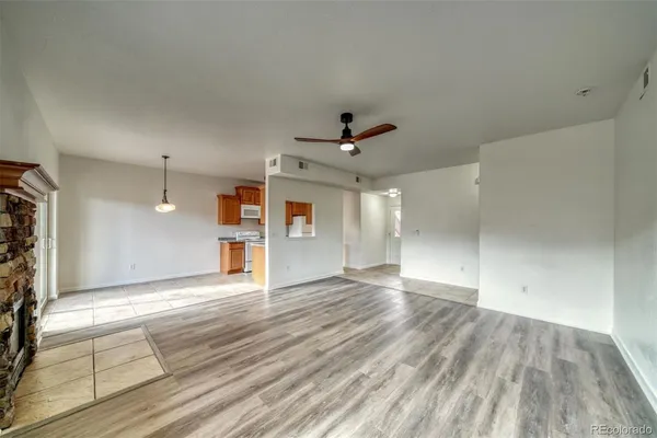 a view of an empty room with window and wooden floor
