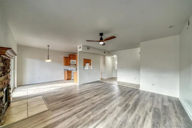 a view of an empty room with window and wooden floor