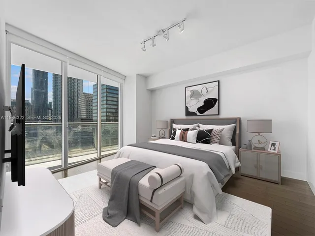 a bedroom with a large bed and a large window