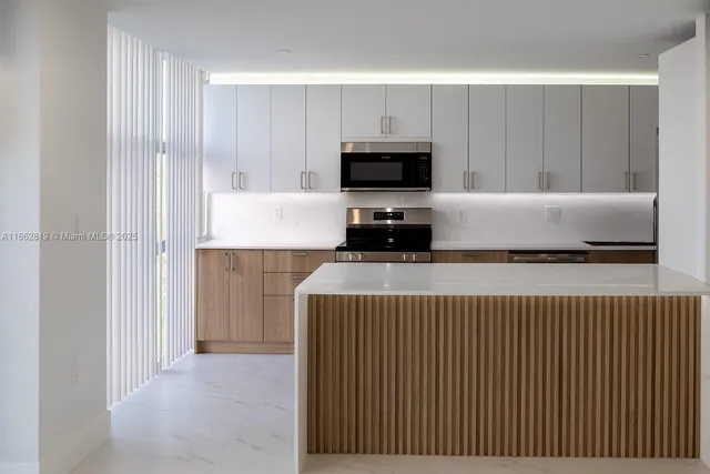 a kitchen with a sink a microwave and cabinets