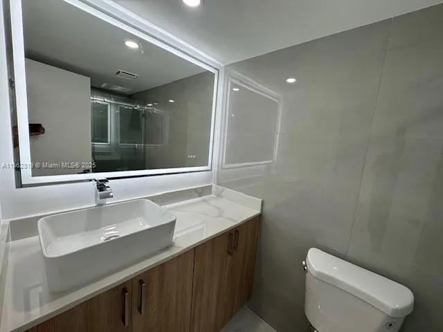 a bathroom with a sink toilet and mirror