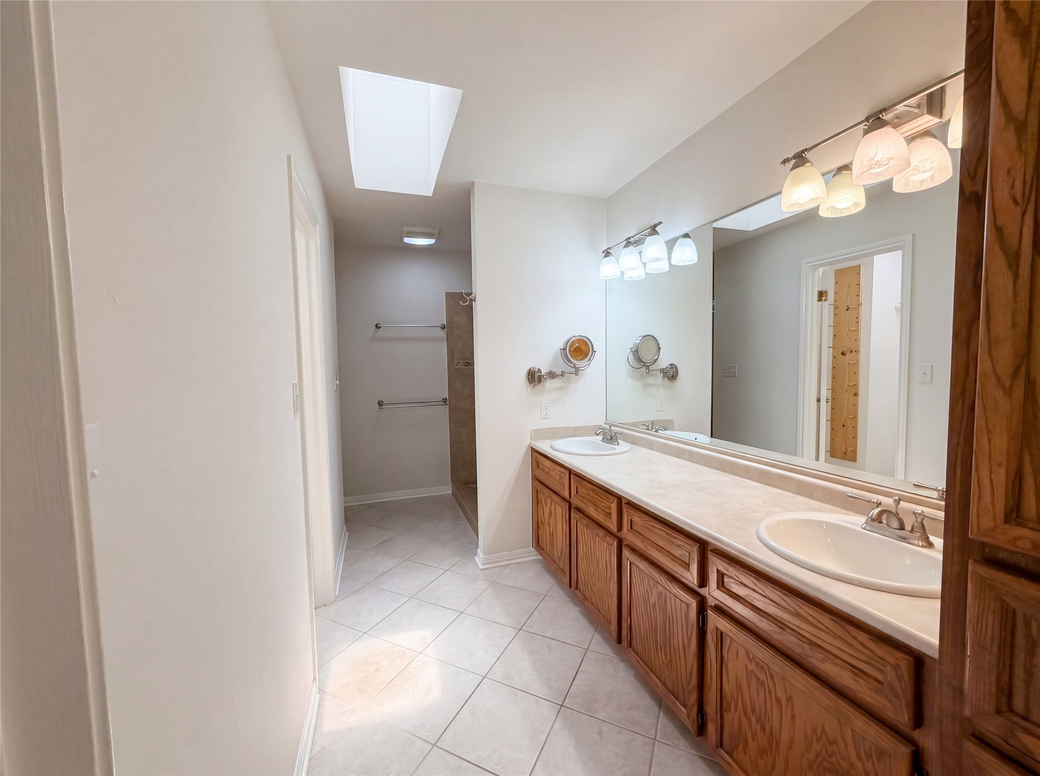 1111 North Riviera Circle Cedar Park, TX 78613 - Photo 12 of 17 Bathroom featuring a dual vanity with oak cabinetry, two undermount sinks, and a light-toned countertop