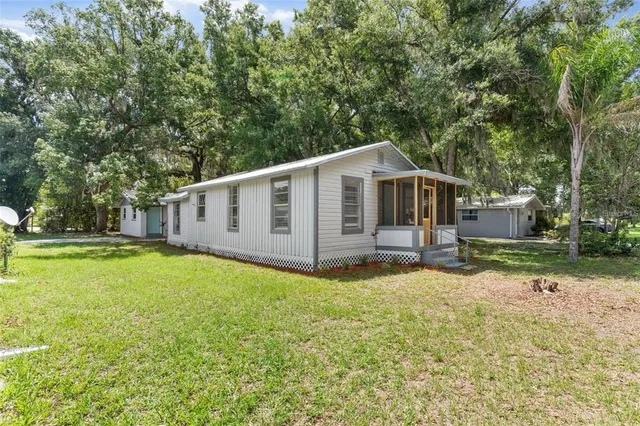 a view of a house with backyard and trees