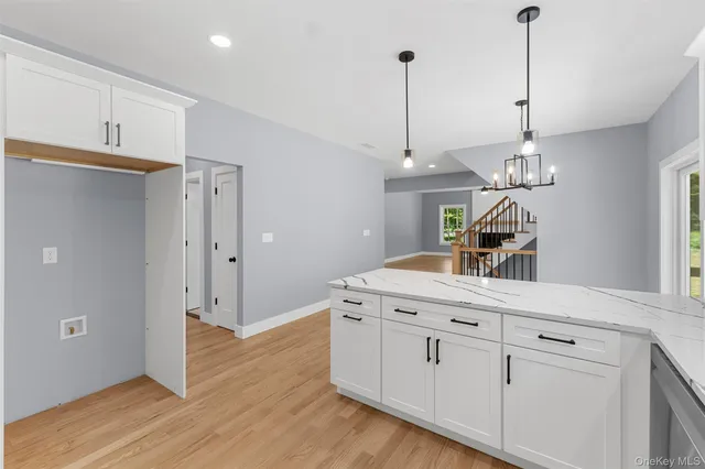 a kitchen with white cabinets and sink
