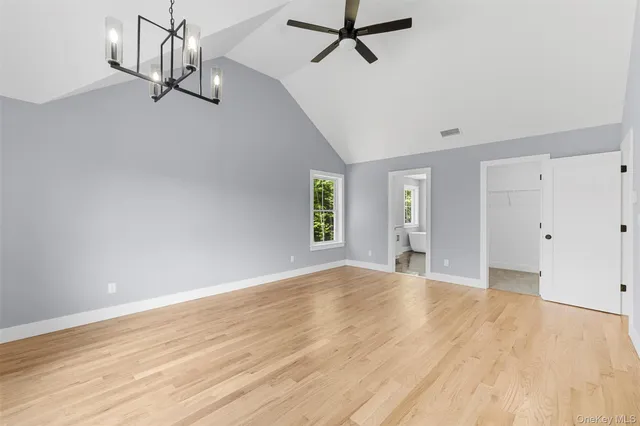 a view of empty room with wooden floor and ceiling fan