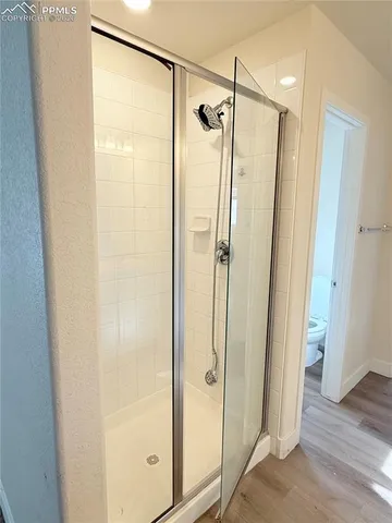 a bathroom with a glass shower door and a glass door