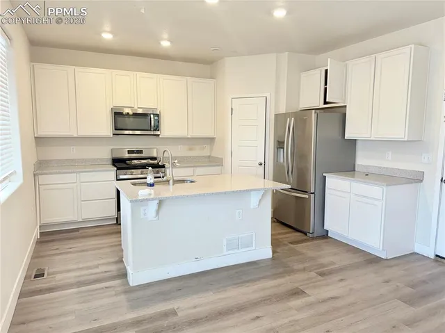 a kitchen with stainless steel appliances a refrigerator stove microwave and cabinets