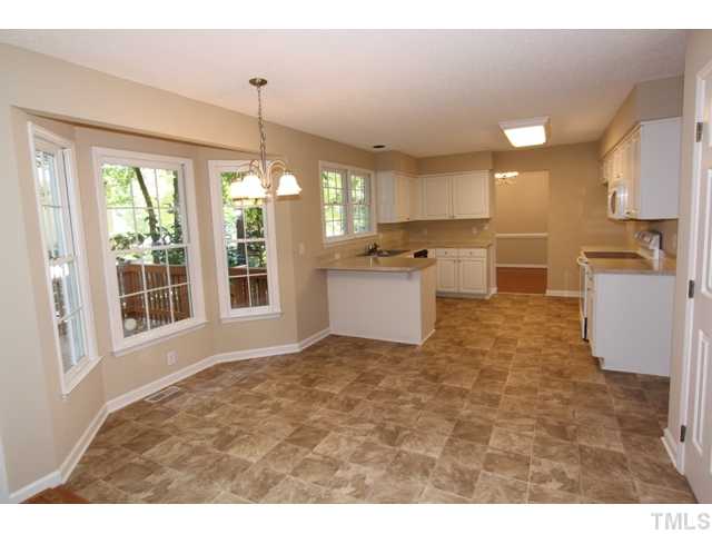 8500 Wheeling Drive Raleigh, NC 27615 - Photo 3 of 24 a large white kitchen with kitchen island a large window in it