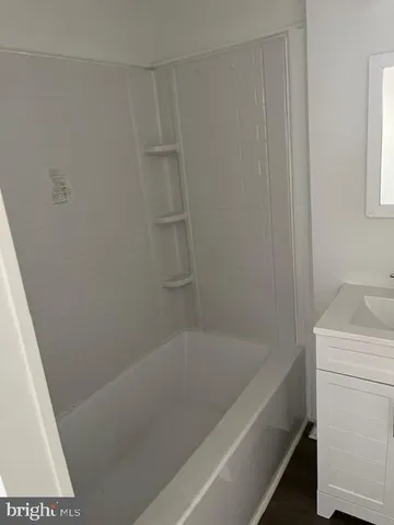 a bath tub sitting next to a white sink and vanity