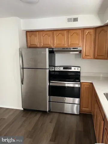 a kitchen with granite countertop a refrigerator and a stove