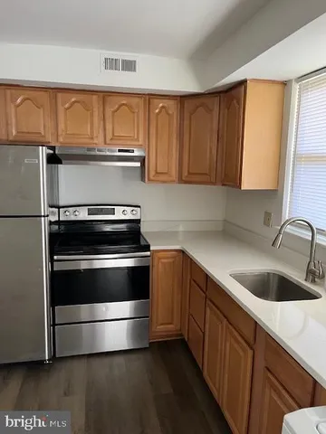 a kitchen with granite countertop a sink and a stove top oven