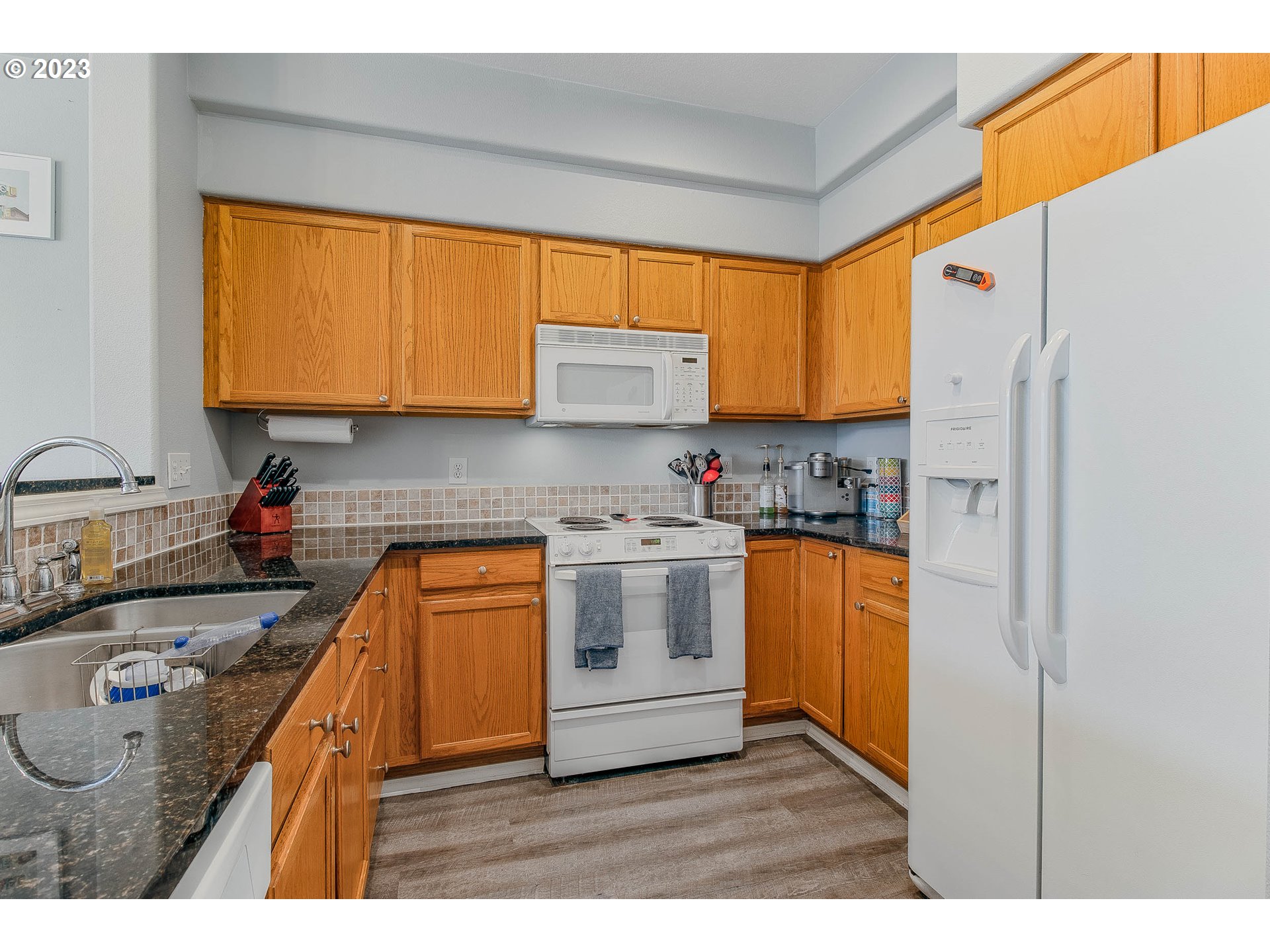 10335 Southwest Denney Road Beaverton, OR 97008 - Photo 13 of 31 a kitchen with granite countertop a sink stainless steel appliances and cabinets