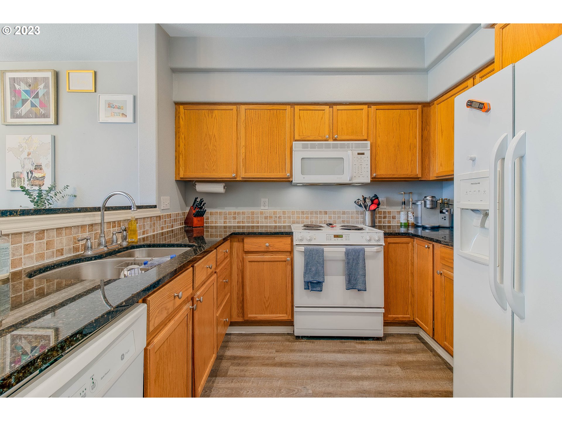 10335 Southwest Denney Road Beaverton, OR 97008 - Photo 15 of 31 a kitchen with stainless steel appliances granite countertop a sink and a refrigerator