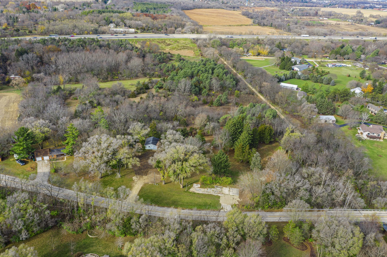 an aerial view of residential houses with outdoor space and trees