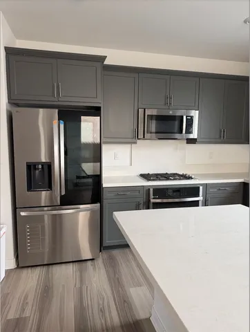 a kitchen with stainless steel appliances a refrigerator and a stove top oven