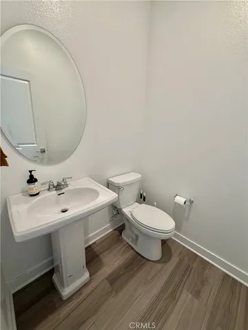 a bathroom with a toilet a sink and mirror