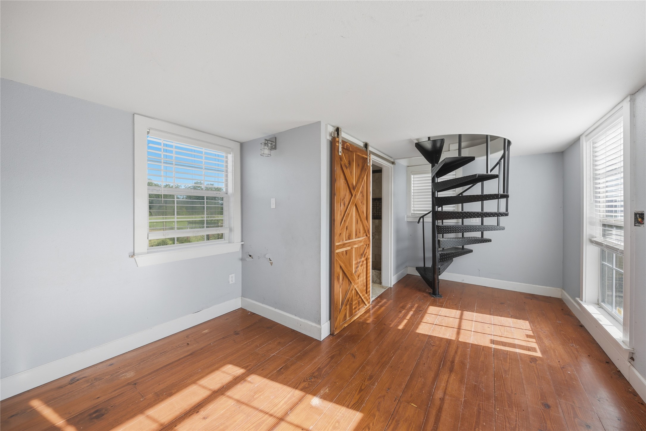 2980 Rabbs Prairie Road La Grange, TX 78945 - Photo 17 of 28 Hardwood floors and a sleek spiral staircase to the upstairs study.