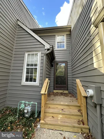 a view of a house with large windows and flower plants