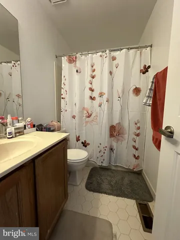 a bathroom with a granite countertop sink a toilet and shower