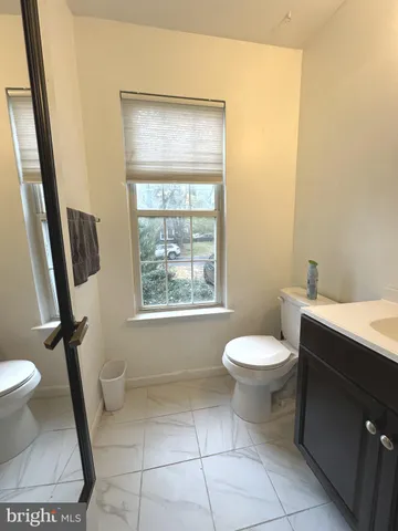 a bathroom with a toilet a sink a bath tub and a window