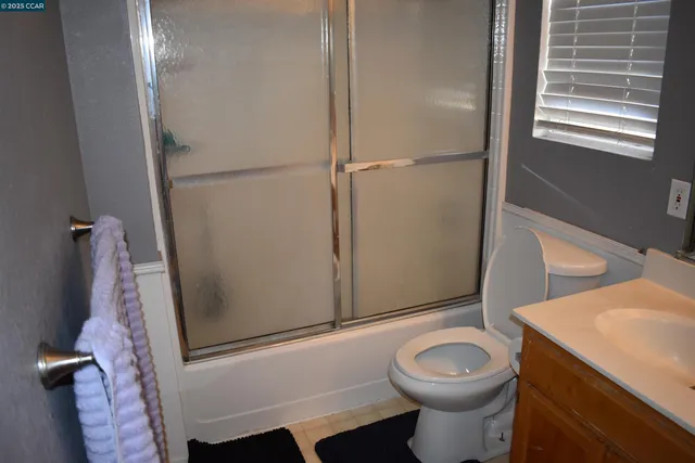 a view of a small space with wooden floor and a ceiling fan