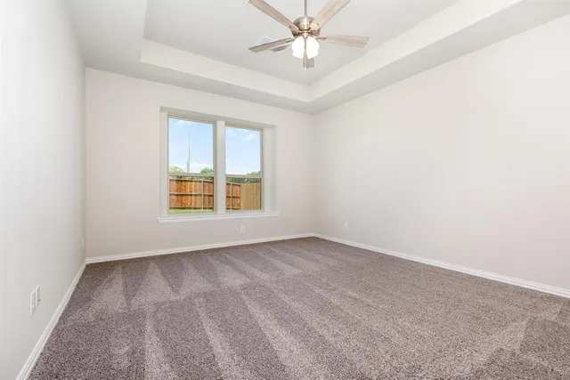 an empty room with a window and a ceiling fan