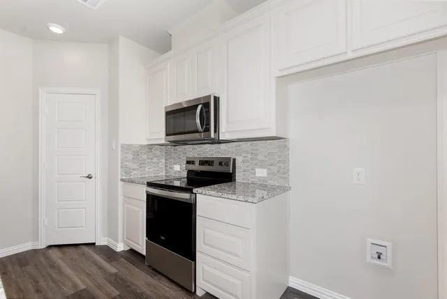 a kitchen with a sink a microwave a refrigerator and cabinets