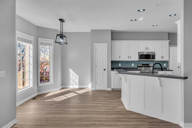 a view of kitchen with sink microwave and cabinets