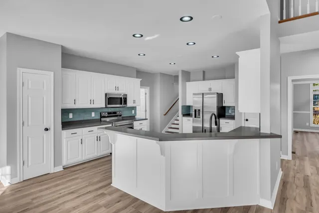 a large kitchen with stainless steel appliances lots of counter space and a sink