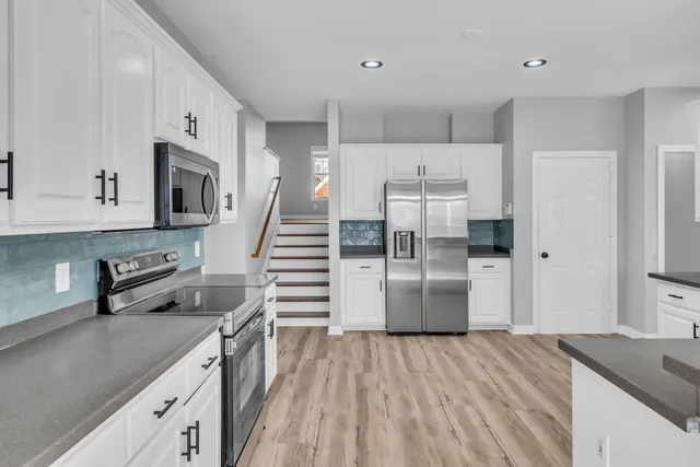 a kitchen with cabinets and wooden floor