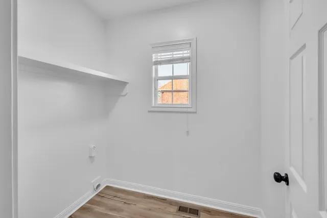 a view of a small space with wooden floor and a window