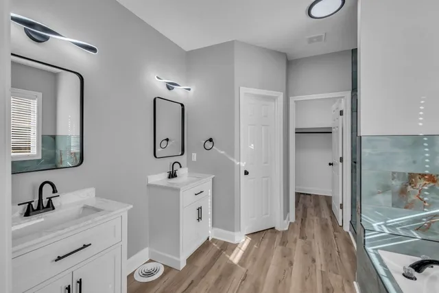 a bathroom with a double vanity sink mirror and shower