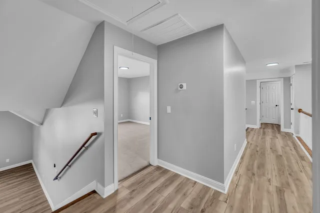 a view of a hallway with wooden floor and staircase