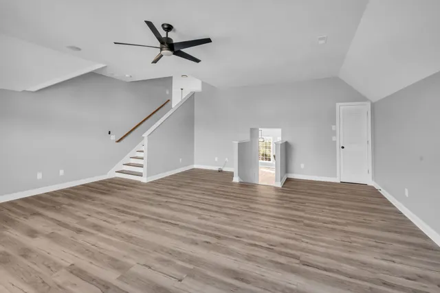 a view of empty room with wooden floor and ceiling fan