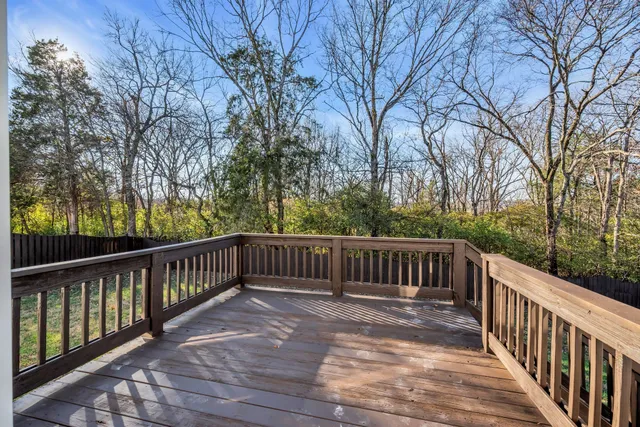 a view of balcony with wooden floor and fence