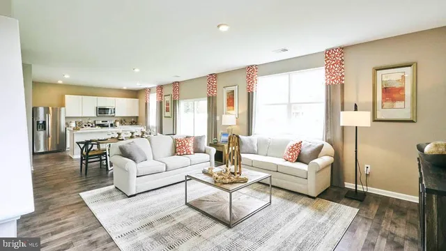 a living room with furniture kitchen view and a large window