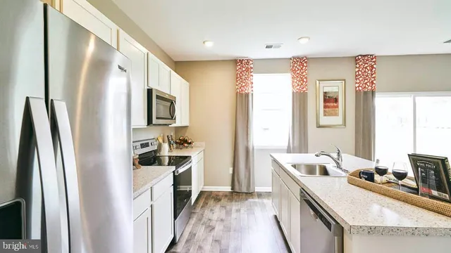 a kitchen with a refrigerator a stove top oven a sink and a refrigerator