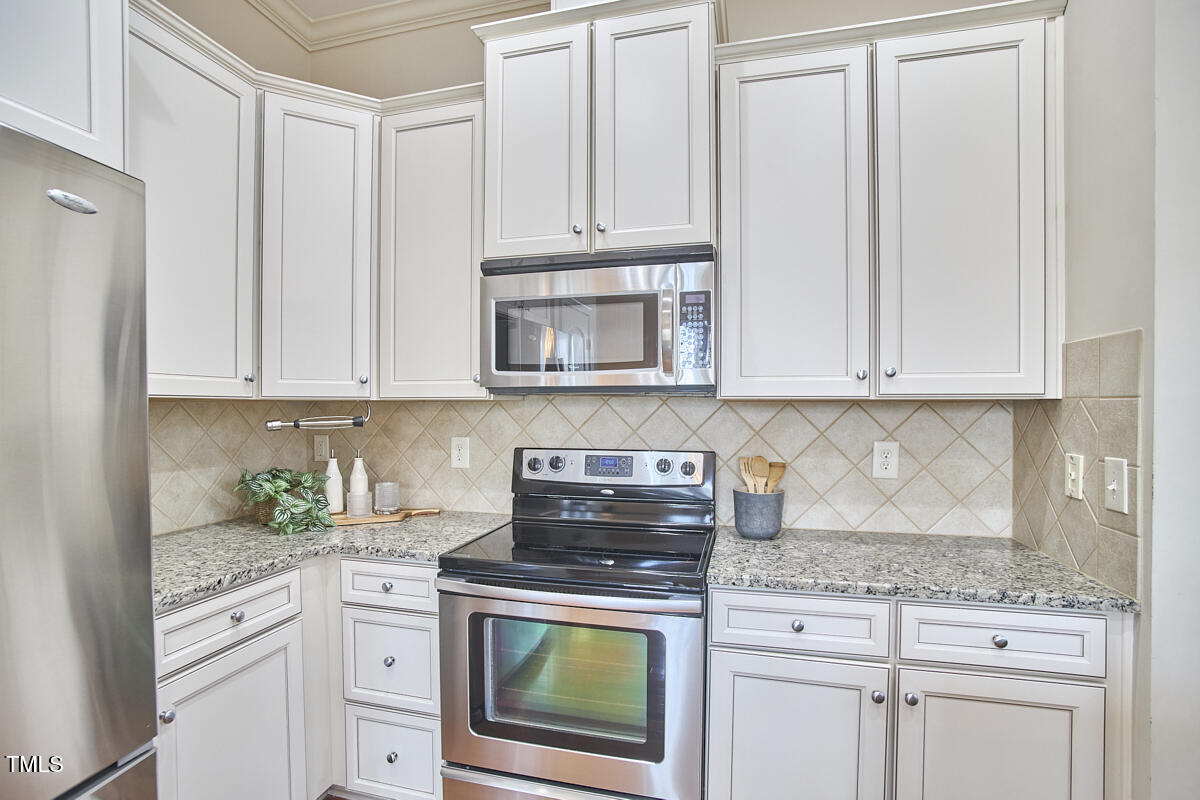 808 Historian Street Raleigh, NC 27603 - Photo 18 of 51 a kitchen with granite countertop white cabinets and stainless steel appliances