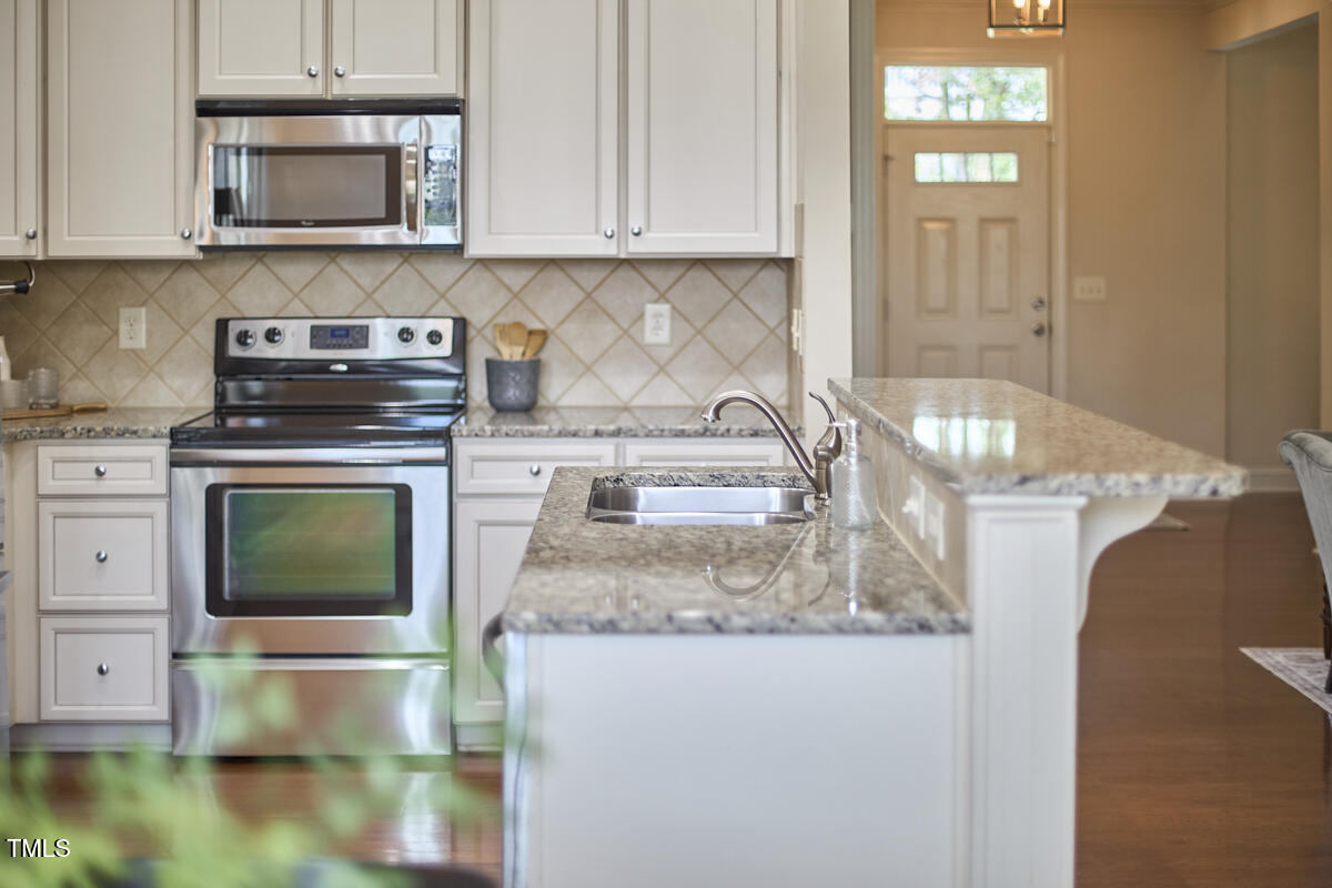 808 Historian Street Raleigh, NC 27603 - Photo 20 of 51 a kitchen with granite countertop a stove and a white cabinets