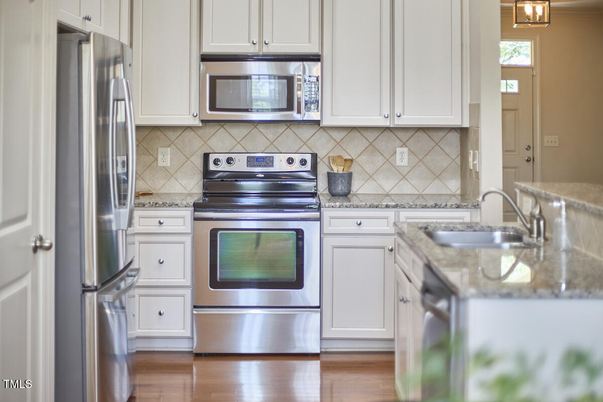 808 Historian Street Raleigh, NC 27603 - Photo 22 of 51 a kitchen with stainless steel appliances granite countertop a stove and a refrigerator
