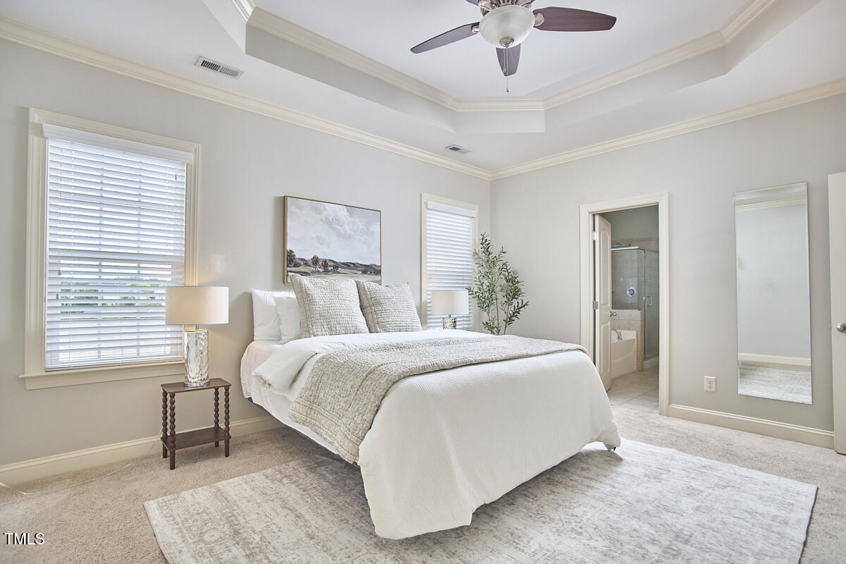 808 Historian Street Raleigh, NC 27603 - Photo 29 of 51 a spacious bedroom with a bed and a chandelier