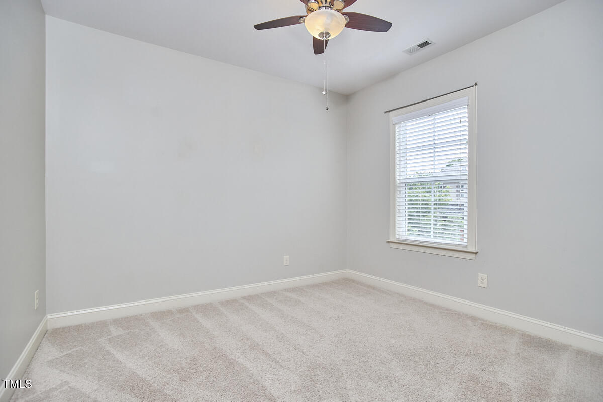 808 Historian Street Raleigh, NC 27603 - Photo 44 of 51 an empty room with a chandelier fan and windows
