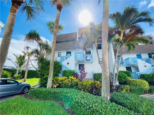 a view of house with swimming pool lawn chairs and palm trees