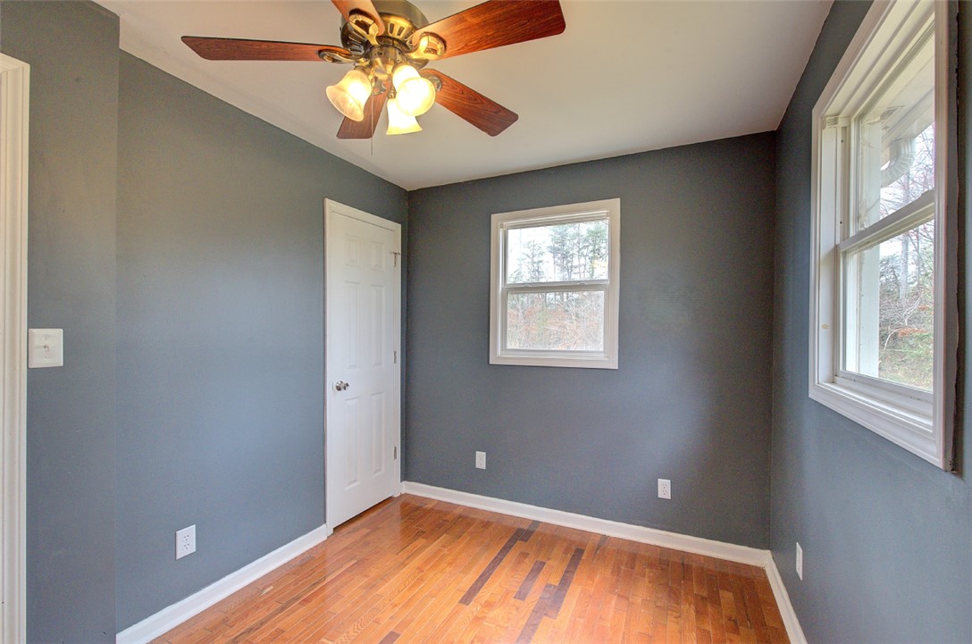 325 Rock Quarry Road Travelers Rest, SC 29690 - Photo 21 of 37 This cozy bedroom features durable hardwood flooring and a functional ceiling fan for comfort.