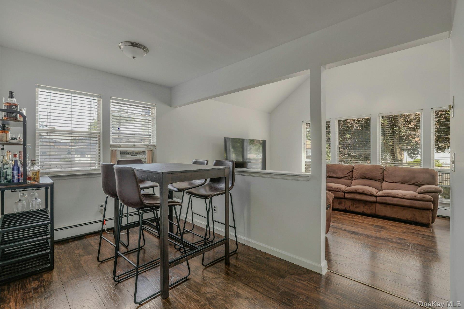 8 Holbrook Street Bay Shore, NY 11706 - Photo 5 of 16 Dining area featuring dark wood finished floors, a baseboard heating unit