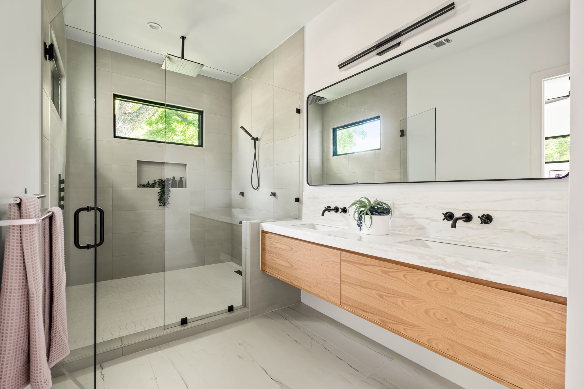 3210 Thompson Street Austin, TX 78702 - Photo 16 of 39 A well-appointed primary bathroom showcases a glass-enclosed shower and a dual-sink vanity with abundant storage.