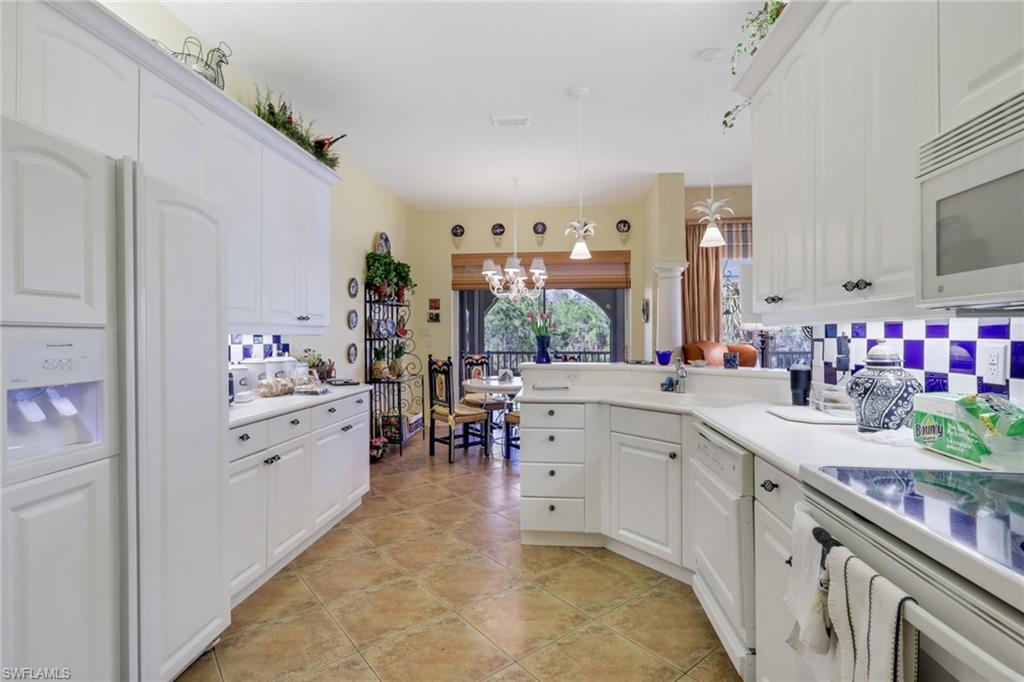 10801 Crooked River Road, Unit 203 Estero, FL 34135 - Photo 11 of 27 a large white kitchen with cabinets