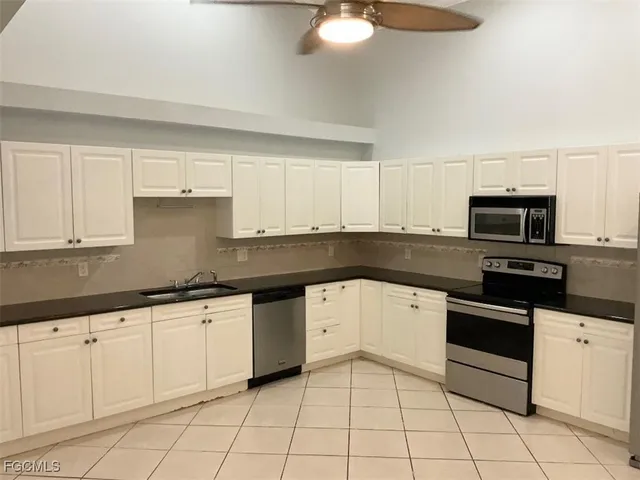 a kitchen with granite countertop white cabinets a sink and dishwasher